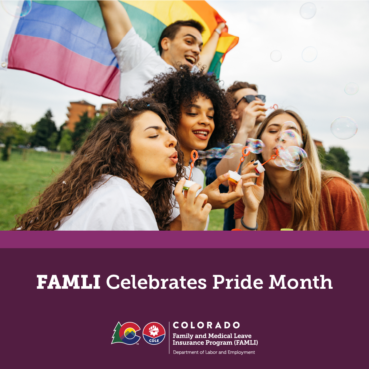 Diverse group of people with the Pride flag behind them