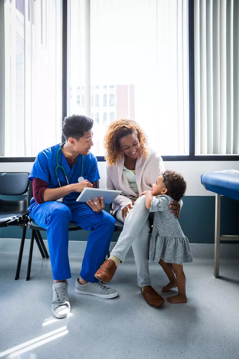 A male nurse consults a woman and her toddler